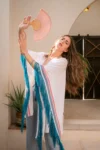 Woman with a fan wearing a blue dress