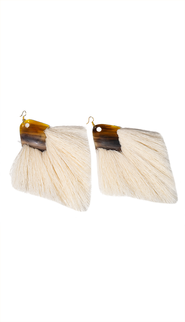 Flat lay of Tuup Earrings with rectangular horn detail and natural fiber fringe.