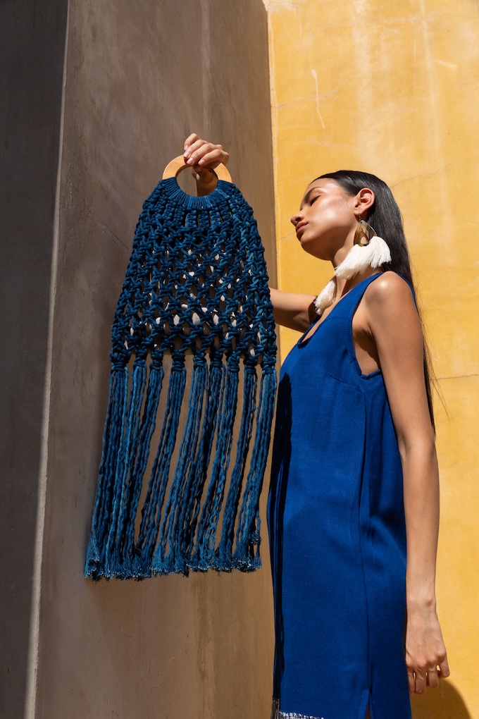 Model holding the Isabel Fringe Bag with caoba wood handle and indigo fringe