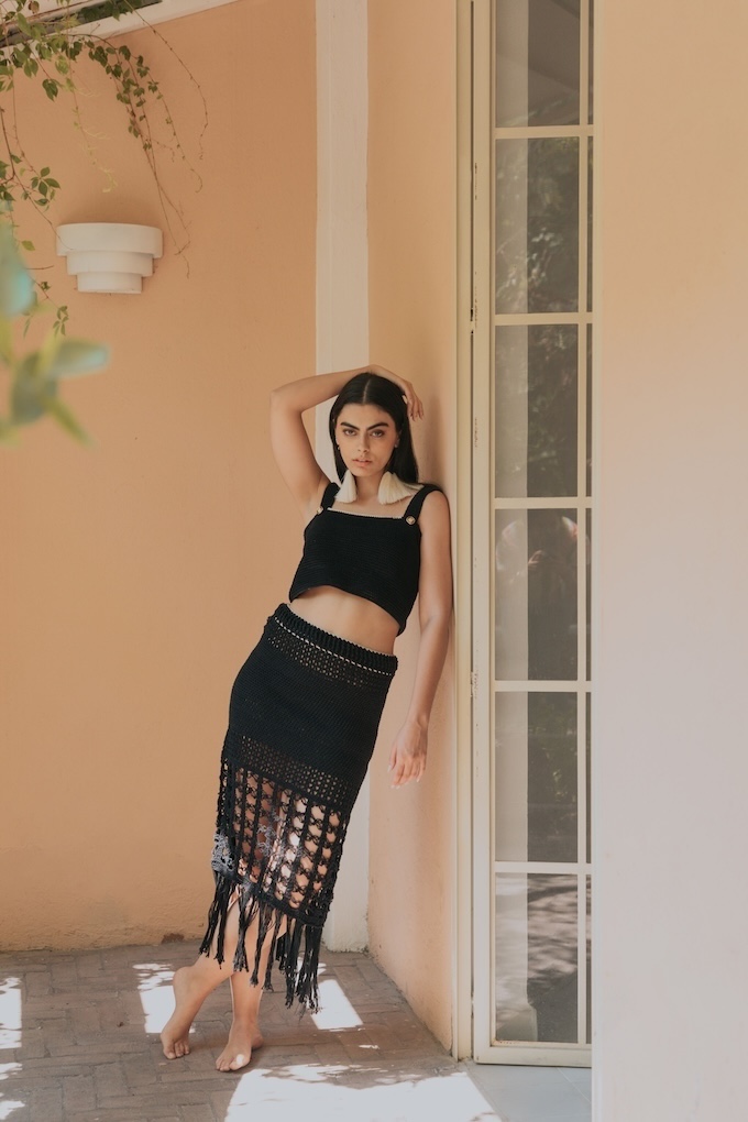 Woman wearing the Tequila crochet midi skirt in black, handwoven in Jalisco with openwork crochet and fringe detail, styled with the matching top.