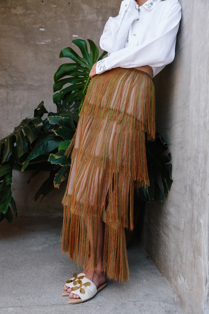 Model wearing the Tule Maxi Fringe Skirt, handcrafted in Chiapas with cascading fringe inspired by Oaxaca’s Árbol del Tule.