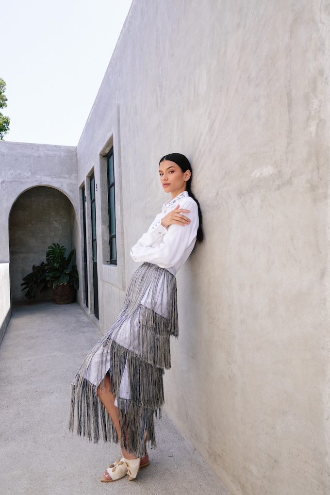 Model wearing the Tule fringe maxi skirt, crafted in linen with layered hand-stitched fringe inspired by the Mexican Tule tree