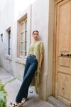 Model wearing the Xpu-Ha Kimono with handwoven fringe, cropped front and long back, styled over wide-leg jeans and artisan sandals.