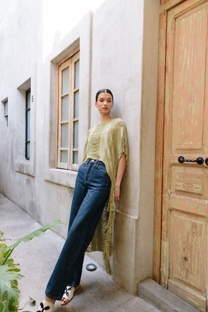 Model wearing the Xpu-Ha Kimono with handwoven fringe, cropped front and long back, styled over wide-leg jeans and artisan sandals.